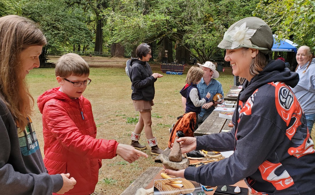 Instructor teaching about Kalapuya Indigenous lifeways at a public event in Oregon